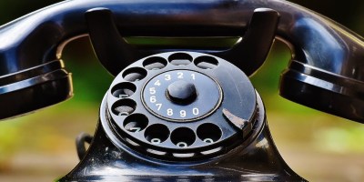 Close up photograph of an old-fashioned 1940's style black rotary dial telephone