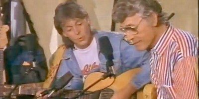 Paul McCartney and Carl Perkins play guitars together.