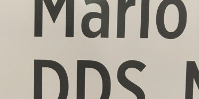 An off-white background with the the name Mario in black type and below it the initials D, D, S.