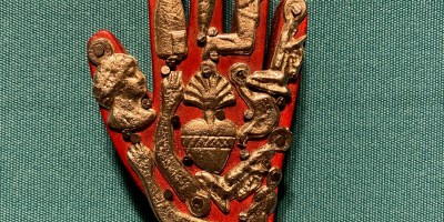 Mexican Milagros charms decorate a red hand