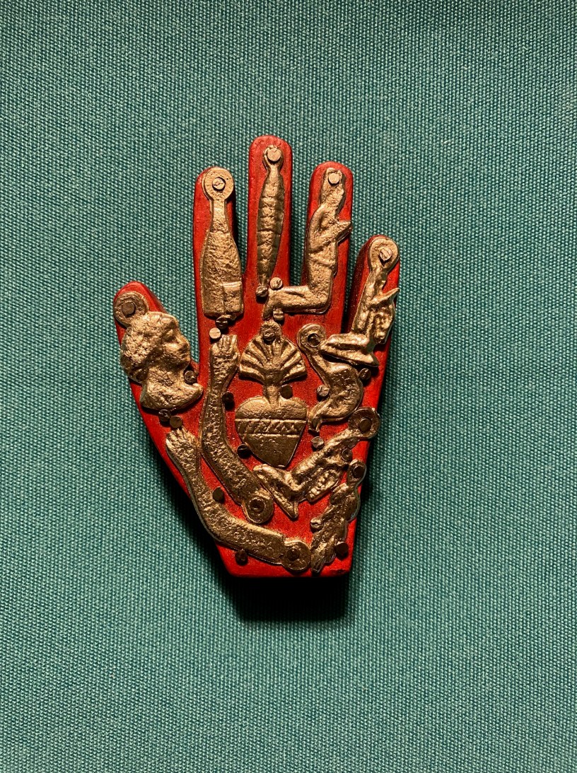 Mexican Milagros charms decorate a red hand