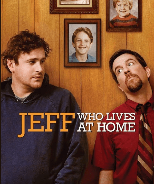 Jason Segel and Ed Helms are in front of panelling with framed photos of them as kids on the wall and in the foreground it says "Jeff Who Lives At Home.”