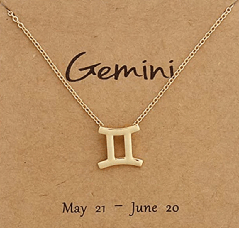 A gold Gemini zodiac sign pendant on a chain with the word Gemini between the chain and underneath the date May 21 to June 20.