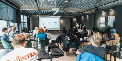 View from the back of a classroom with adult students facing the whiteboard.