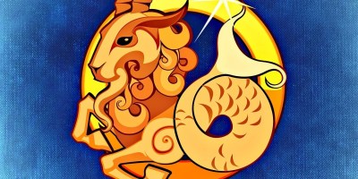 An image of the Capricorn symbol of a sea goat with the head of a goat and tail of a fish on a blue background with Capricorn written below it.